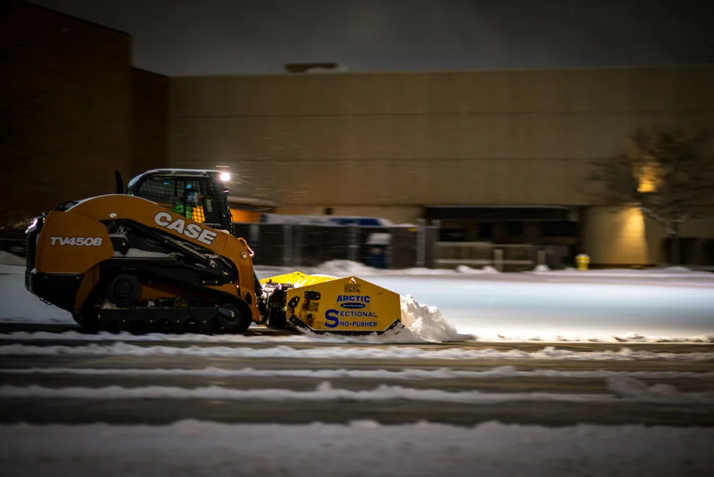 Skid steer clearing deep snow on rural Winnipeg driveway